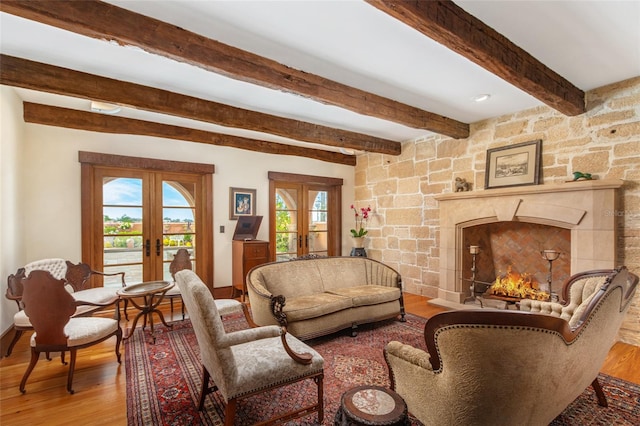 living room with french doors, light hardwood / wood-style flooring, and beamed ceiling