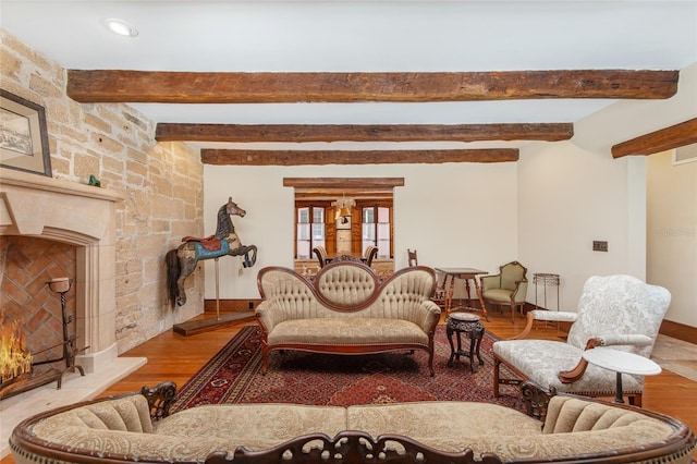 sitting room featuring a fireplace, beam ceiling, and light hardwood / wood-style flooring