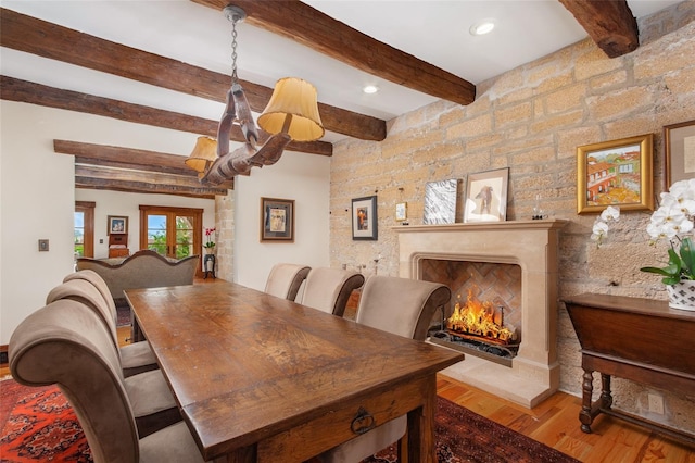 dining area with beam ceiling and hardwood / wood-style floors