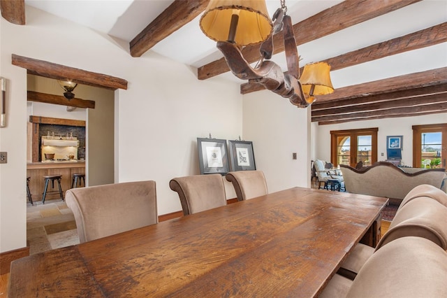 dining space with beamed ceiling and french doors