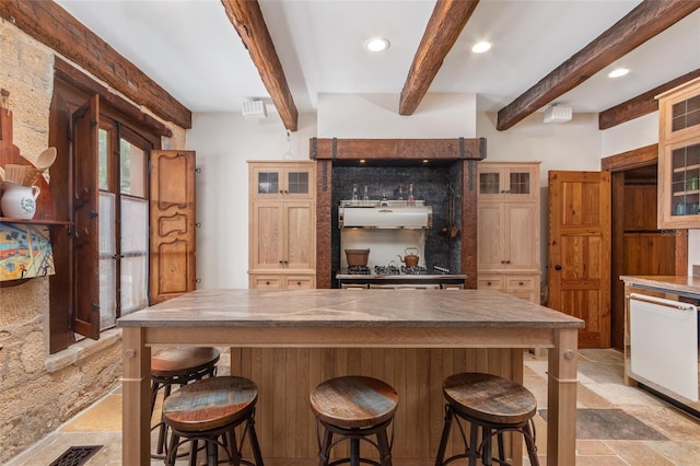 kitchen featuring beamed ceiling, a center island, and dishwasher