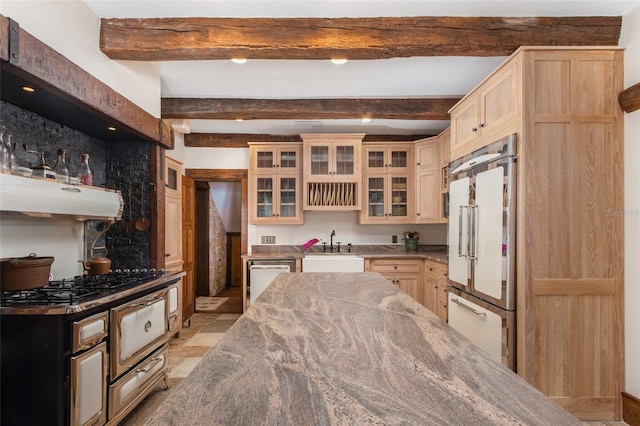 kitchen featuring beam ceiling, appliances with stainless steel finishes, sink, and light brown cabinetry