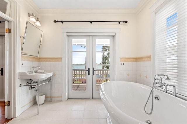 bathroom featuring tile walls, a bathtub, a water view, tile patterned floors, and french doors