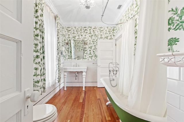 full bathroom with crown molding, toilet, shower / bath combination with curtain, and hardwood / wood-style floors