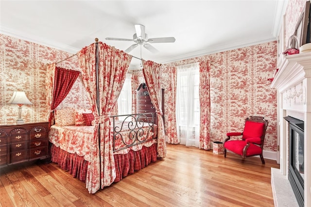 bedroom with ceiling fan, ornamental molding, and wood-type flooring