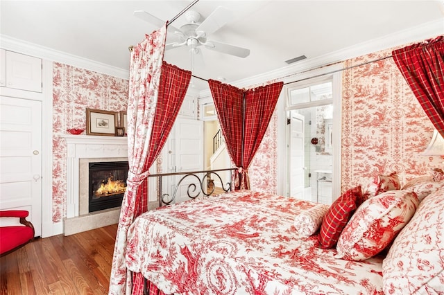 bedroom featuring ceiling fan, ornamental molding, hardwood / wood-style floors, and ensuite bath