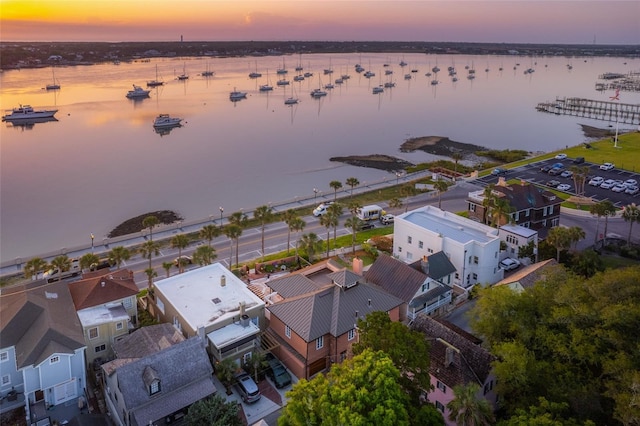 aerial view at dusk featuring a water view