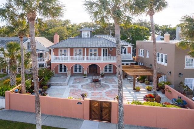 view of front of property with a patio, a balcony, a pergola, and french doors