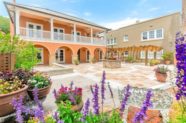 back of property with ceiling fan, a patio, and a balcony