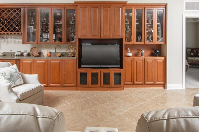 living room with light tile patterned floors and indoor bar