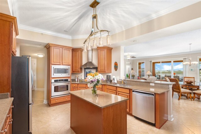 kitchen with appliances with stainless steel finishes, pendant lighting, a kitchen island, crown molding, and sink