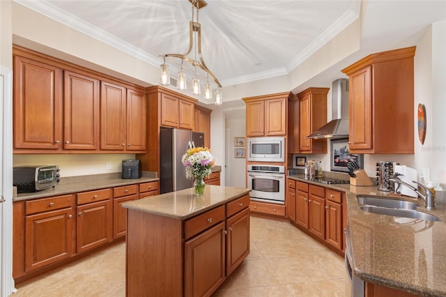 kitchen with a center island, sink, hanging light fixtures, stainless steel appliances, and wall chimney exhaust hood