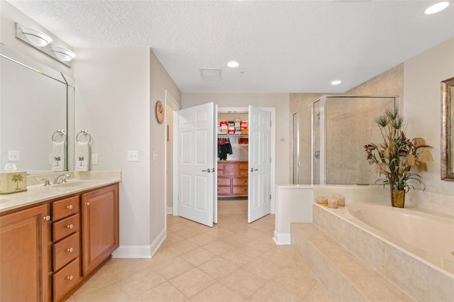 bathroom featuring a textured ceiling, tile patterned floors, vanity, and independent shower and bath