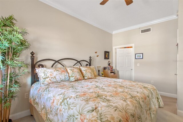 carpeted bedroom with ceiling fan and ornamental molding