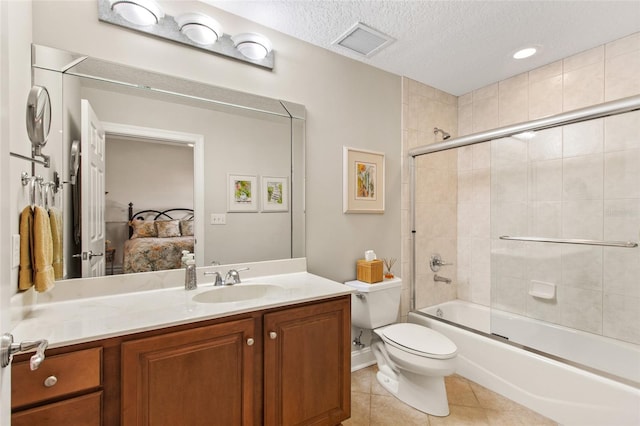 full bathroom featuring a textured ceiling, tile patterned floors, vanity, toilet, and combined bath / shower with glass door