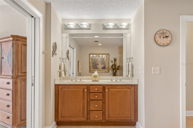 bathroom featuring a textured ceiling, tile patterned flooring, and vanity