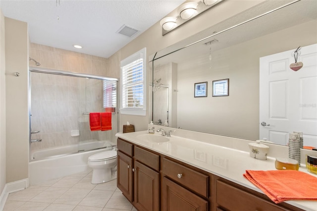 full bathroom featuring toilet, vanity, tiled shower / bath combo, and tile patterned floors