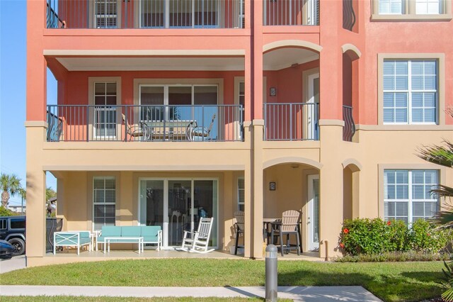 back of house featuring a balcony and a patio