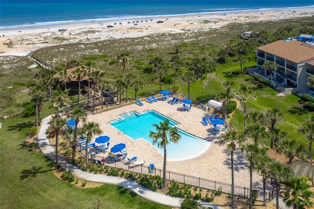 view of pool with a beach view, a patio area, and a water view