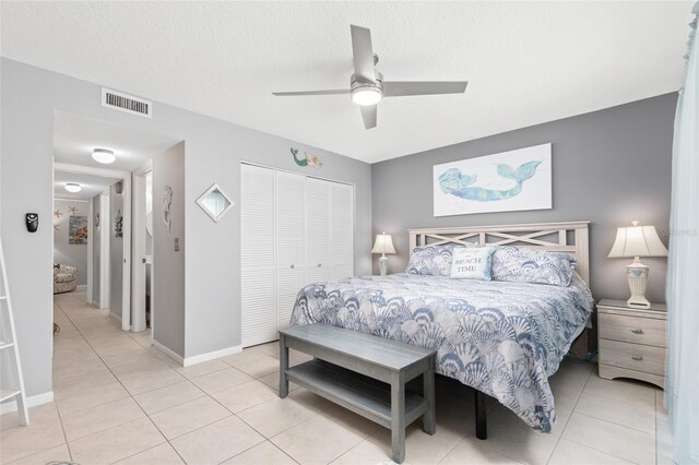 tiled bedroom featuring ceiling fan and a closet