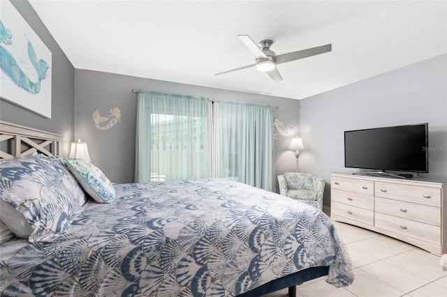 bedroom featuring a textured ceiling, ceiling fan, and light tile patterned floors