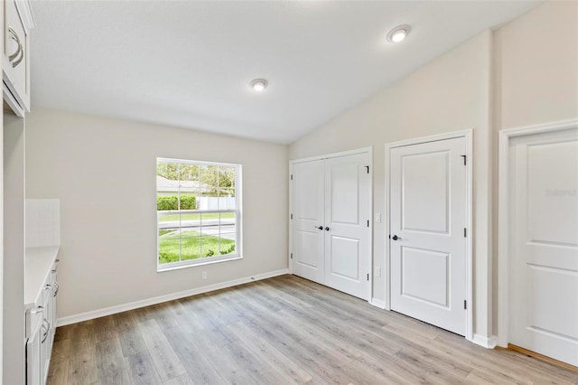 66 Ryland Dr, Palm Coast, FL 32164 - unfurnished bedroom with vaulted ceiling and light wood-type flooring