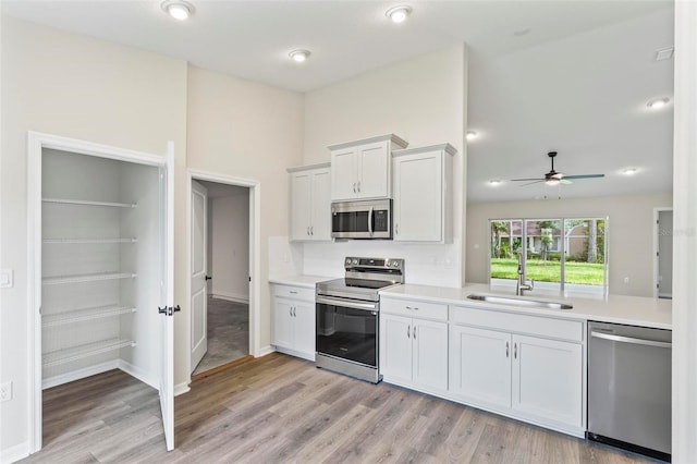 66 Ryland Dr, Palm Coast, FL 32164 - kitchen featuring ceiling fan, sink, light hardwood / wood-style flooring, white cabinets, and appliances with stainless steel finishes