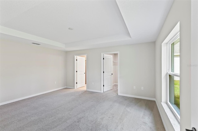 66 Ryland Dr, Palm Coast, FL 32164 - carpeted empty room featuring a tray ceiling and a healthy amount of sunlight