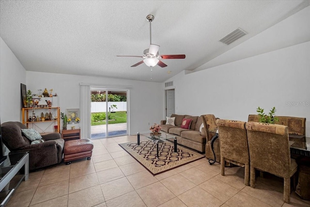 tiled living room featuring a textured ceiling, ceiling fan, and lofted ceiling