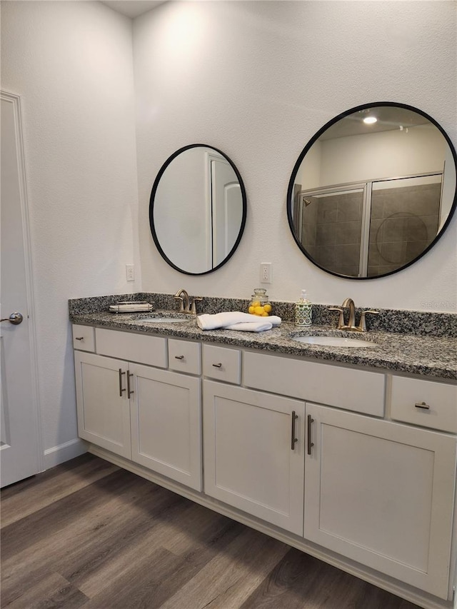 bathroom featuring walk in shower, wood-type flooring, and vanity