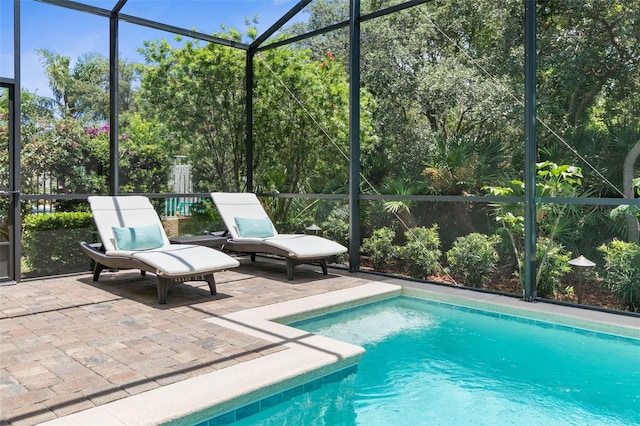 view of swimming pool with glass enclosure and a patio area