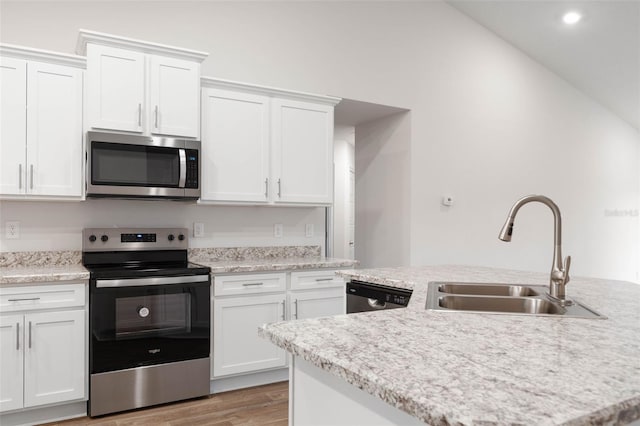 kitchen featuring stainless steel appliances, lofted ceiling, white cabinets, and sink