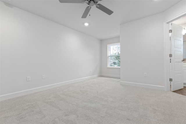 unfurnished room with ceiling fan and light colored carpet