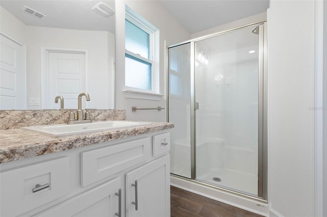 bathroom featuring vanity, wood-type flooring, and an enclosed shower