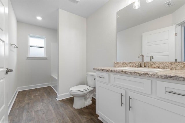 full bathroom featuring washtub / shower combination, wood-type flooring, toilet, and vanity