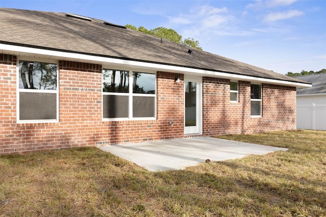 rear view of house with a patio area and a lawn