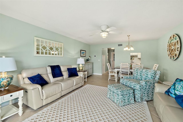 living room featuring ceiling fan with notable chandelier and light tile patterned flooring