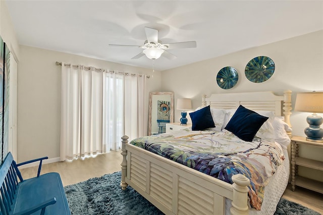 bedroom with light hardwood / wood-style flooring, a closet, and ceiling fan