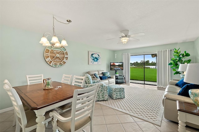 dining area featuring light tile patterned floors and ceiling fan with notable chandelier