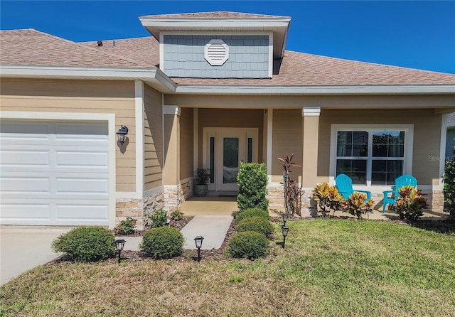 entrance to property with a garage and a yard