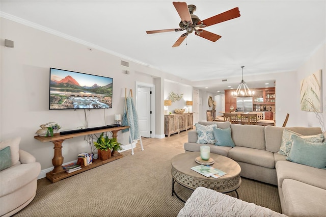 living room featuring ceiling fan with notable chandelier, crown molding, and light carpet