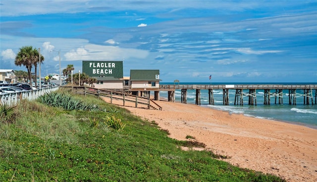 view of dock with a water view and a view of the beach