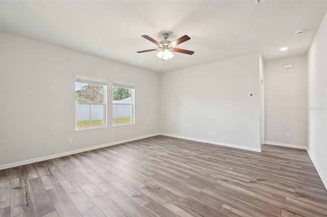 spare room with hardwood / wood-style flooring and ceiling fan