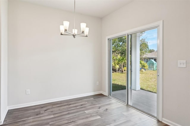 doorway to outside featuring hardwood / wood-style flooring and an inviting chandelier