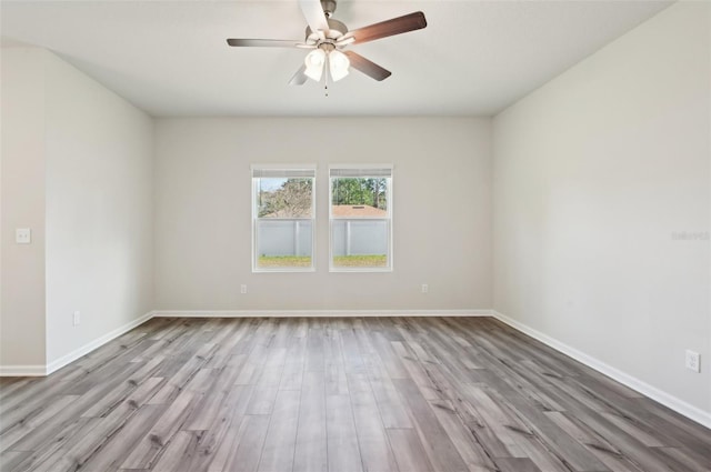 empty room with ceiling fan and light hardwood / wood-style floors