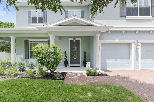 view of front facade with a porch, a garage, and a front lawn