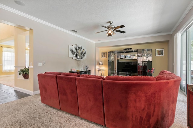 carpeted living room featuring ornamental molding, a wealth of natural light, and ceiling fan