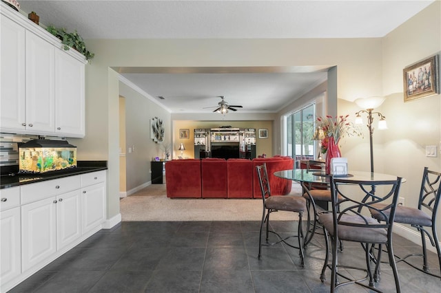 tiled dining area with crown molding and ceiling fan