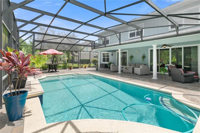 view of pool featuring an outdoor living space, ceiling fan, a patio area, and a lanai