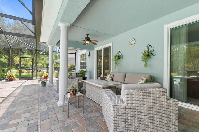 view of patio / terrace featuring glass enclosure, outdoor lounge area, and ceiling fan